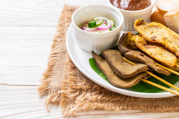 Satay de porco com seu molho de amendoim e picles que são cucumbe — Fotografia de Stock