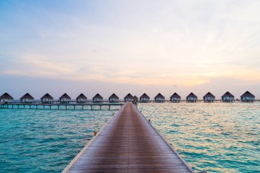 Su bungal ile Maldivler Adası üzerinde güzel tropikal günbatımı