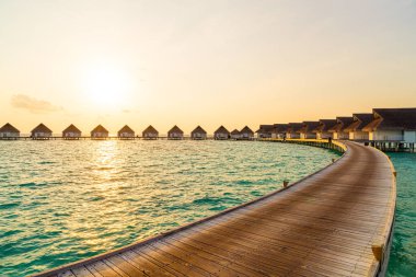 Su bungal ile Maldivler Adası üzerinde güzel tropikal günbatımı