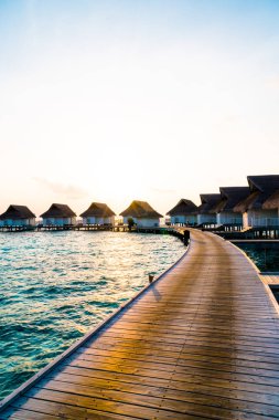 Su bungal ile Maldivler Adası üzerinde güzel tropikal günbatımı