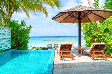 Maldivler yüzme havuzu ve deniz arka plan ile plaj sandalyesi