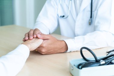 Doktorun eli kadın hastasına güvence veriyor.