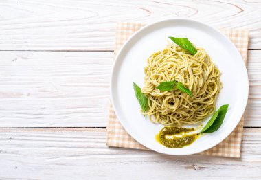 Spagetti pesto sos, zeytin yağı ve fesleğen yaprakları ile.