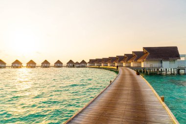 Su bungal ile Maldivler Adası üzerinde güzel tropikal günbatımı
