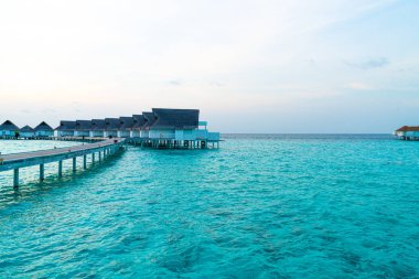 Su bungal ile Maldivler Adası üzerinde güzel tropikal günbatımı