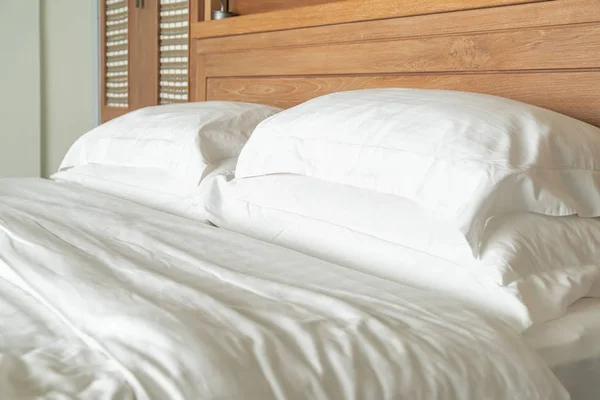 Белая подушка на декоре кровати в спальне отеля — стоковое фото