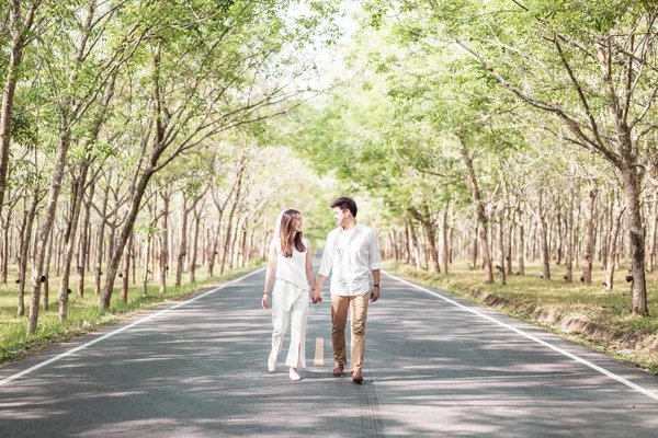 Gelukkige Aziatische paar verliefd op weg met boom boog — Stockfoto