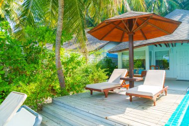 Maldivler yüzme havuzu ve deniz arka plan ile plaj sandalyesi