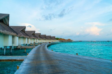 Su bungal ile Maldivler Adası üzerinde güzel tropikal günbatımı