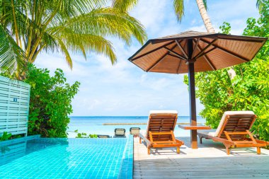 Maldivler yüzme havuzu ve deniz arka plan ile plaj sandalyesi