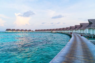 Su bungal ile Maldivler Adası üzerinde güzel tropikal günbatımı