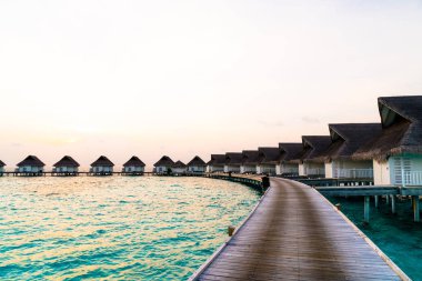 Su bungal ile Maldivler Adası üzerinde güzel tropikal günbatımı
