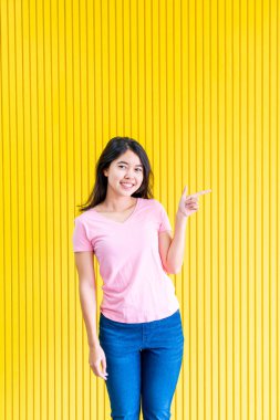 sarı duvar üzerinde ayakta Genç Asyalı kadın mutluluk