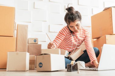 Asya kadın iş sahibi çalışan evde ambalaj kutusu ile w