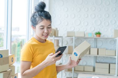 Asya kadın iş sahibi çalışan evde ambalaj kutusu ile w