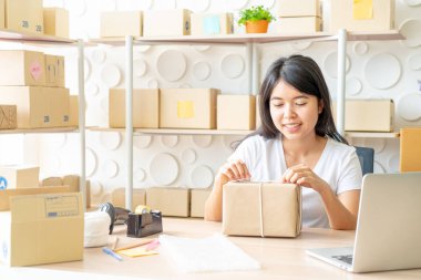 Asya kadın iş sahibi çalışan evde ambalaj kutusu ile w