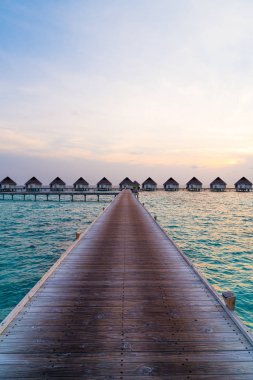 Su bungal ile Maldivler Adası üzerinde güzel tropikal günbatımı
