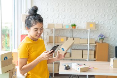 Asya kadın iş sahibi çalışan evde ambalaj kutusu ile w