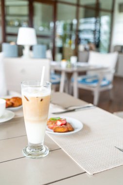 kafe restoranda masa üzerinde latte kahve camı