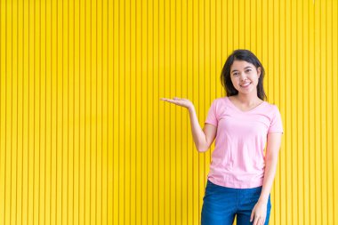 sarı duvar üzerinde ayakta Genç Asyalı kadın mutluluk