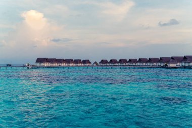 Su bungal ile Maldivler Adası üzerinde güzel tropikal günbatımı