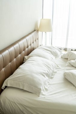 Yatakta beyaz yastık ve battaniye ile dağınık yatak 