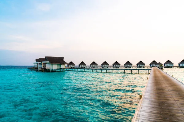 Su bungal ile Maldivler Adası üzerinde güzel tropikal günbatımı