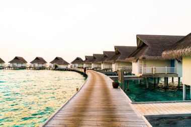 Su bungal ile Maldivler Adası üzerinde güzel tropikal günbatımı