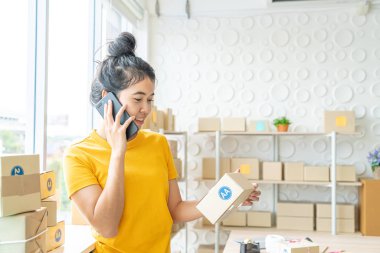 Asya kadın iş sahibi çalışan evde ambalaj kutusu ile w