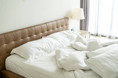 Yatakta beyaz yastık ve battaniye ile dağınık yatak 