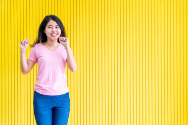 sarı duvar üzerinde ayakta Genç Asyalı kadın mutluluk