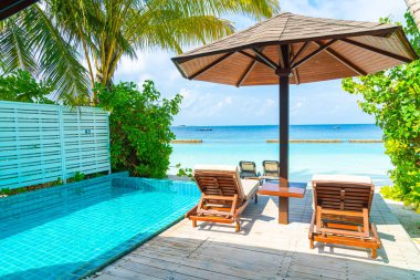 Maldivler yüzme havuzu ve deniz arka plan ile plaj sandalyesi