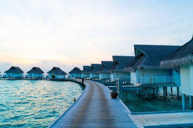 Su bungal ile Maldivler Adası üzerinde güzel tropikal günbatımı