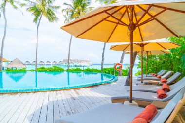 Şemsiye ve sandalye tatil otelde yüzme havuzu etrafında 