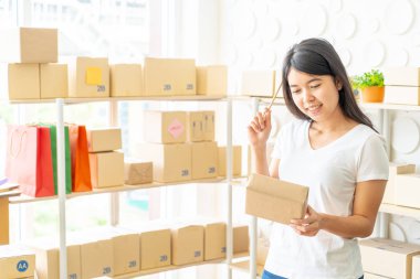 Asya kadın iş sahibi çalışan evde ambalaj kutusu ile w