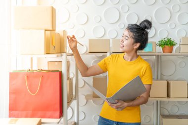  Genç Asyalı kadın ambar stok raf üzerinde mal kontrol