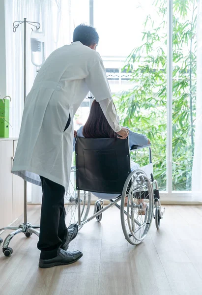 Paziente donna sulla sedia a rotelle con medico senior — Foto Stock