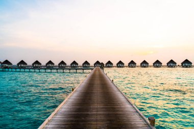 Su bungal ile Maldivler Adası üzerinde güzel tropikal günbatımı