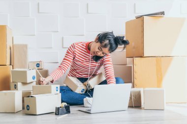 Asya kadın iş sahibi çalışan evde ambalaj kutusu ile w