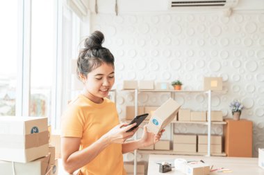 Asya kadın iş sahibi çalışan evde ambalaj kutusu ile w