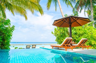 Maldivler yüzme havuzu ve deniz arka plan ile plaj sandalyesi