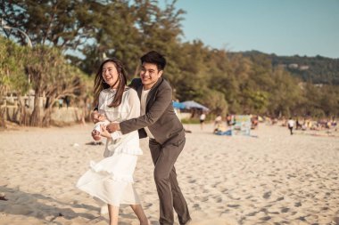 Mutlu çift balayı gidiş tropikal kum plajı üzerinde su içinde seyahat.