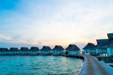 Su bungal ile Maldivler Adası üzerinde güzel tropikal günbatımı