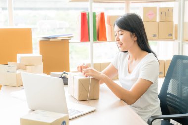 Asya kadın iş sahibi çalışan evde ambalaj kutusu ile w