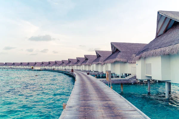 Su bungal ile Maldivler Adası üzerinde güzel tropikal günbatımı