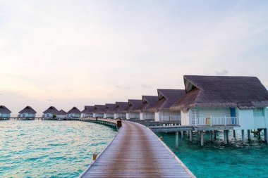 Su bungal ile Maldivler Adası üzerinde güzel tropikal günbatımı
