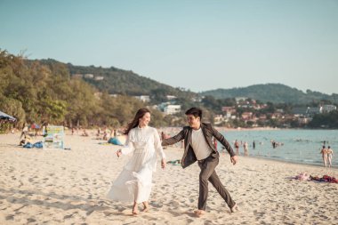 Mutlu çift balayı gidiş tropikal kum plajı üzerinde su içinde seyahat.