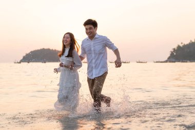 Mutlu çift balayı gidiş tropikal kum plajı üzerinde su içinde seyahat.