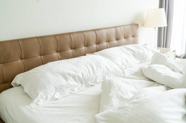 Yatakta beyaz yastık ve battaniye ile dağınık yatak 