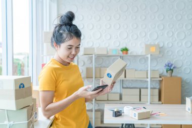 Asya kadın iş sahibi çalışan evde ambalaj kutusu ile w